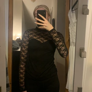 Svart spets topp - Denna top är täckt med svart spets men har en avformning vid överdelen av kroppen som man kan se på bilderna.  Materialet är stretchigt och själva toppen kan bli lättare att ta på sig då den har en uppknäppning längst upp i nacken.🤍 Jag har använt toppen 3/4 gånger men är annars i gott skick