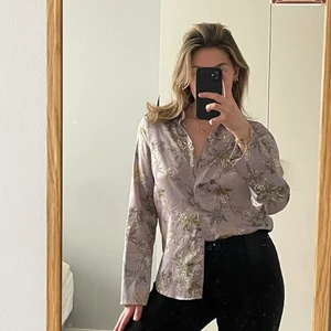 Blommig blus - Blommig blus från Gina Tricot! Ljuslila med utsvängda armar. Använd ca 3 gånger. Strl 34 men mer lik 36!