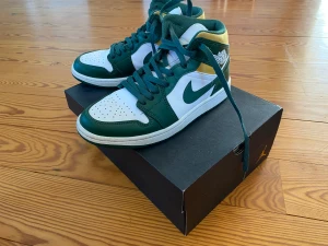 Air Jordan 1 mid Sonics + box - Jag säljer nu min brors Air Jordan 1s i storlek 40 efter som de tyvärr har blivit för små för honom. Dom har använts ett fåtal gånger och är i mycket bra skick. Box finns men köpare står för frakt. 