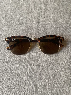 Solglasögon Ray-Ban Clubmaster - Säljer ett par solglasögon från Ray-Ban, modell Clubmaster. Nästintill aldrig använda (nyskick).   Finns att hämta i Väröbacka. 
