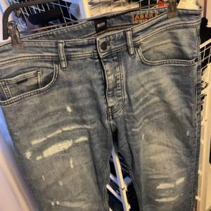 Blåa, ripped jeans från Hugo Boss. Tapered fit, Storlek 33/32. Ny pris runt 2000. Pris går att diskutera.