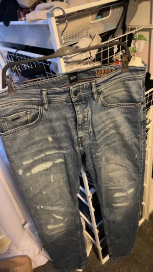 Hugo boss Jeans. - Blåa, ripped jeans från Hugo Boss. Tapered fit, Storlek 33/32. Ny pris runt 2000. Pris går att diskutera.