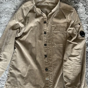 C.P. Company overshirt - Tjo! Säljer en skön overshirt från C.P Company i storlek L då den har blivit alldeles för liten. Perfekt nu inför våren! Inköpt på CENINO DONNA för 2500kr våren 2022. För övrigt bra skick på tröjan, bara ett litet skrapmärke på själva badgen.