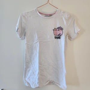 T-shirt med Pusheen - Pusheen är en drake! Söt t-shirt men kommer tyvärr inte till användning. Hör av dig om du har frågor!