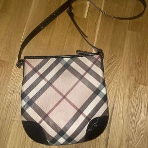 Burberry axelväska år 2009 - Burberry axelväska använd mellan 2009 och 2013 God skick med några små repor  Stl 26X28 cm Kommer med original dustbag