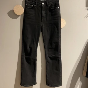 26/28 jeans från &Otherstpries. Nyskick! - Superfina jeans med rak modell och medelhög midja. I svart/grå tvätt. Aldrig använda, enbart provade. Strl 26 i midjan och 28 cm längd. I mycket gott skick!