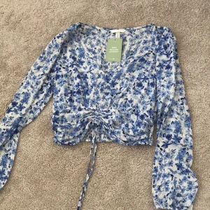 Croppad sommar blus - Blå, blommig croppad sommar blus från H&M. Aldrig använd. 