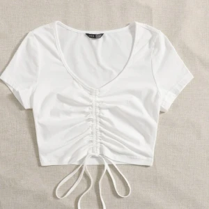 Topp - Så fin vit topp med fin detalj i mitten.🤍 Toppen går att knyta om man vill att den ska sitta åt mer eller mindre. Storlek XS. Köparen står för frakt!