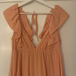 Orange klänning - Otrolig orange klänning från H&M, urringad och öppen i ryggen. En riktig dröm till sommaren!