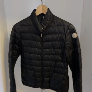 Moncler jacka - Äkta, ska meddelande för fler bilder. Finns flera små hål i jackan  så dunet har åk ut på vissa ställen. Fläckar vid halsen också se bilder. Använt flitigt, men ändå fint skick som inte syns tydligt när man har på. 
