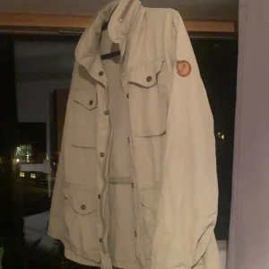 Fjällräven Jacka  - Säljer nu min Fjällräven jacka köpt i Österrike för länge sedan. Jackan är knappt använd och därmed inga skador. Jackan har även möjlighet att få luva genom att simpelt bara öppna ”fickan” vid nacken. Priset är inte fast!