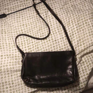 Svart skinn väska  - Svart skinn väska med justerbar band , bra skick