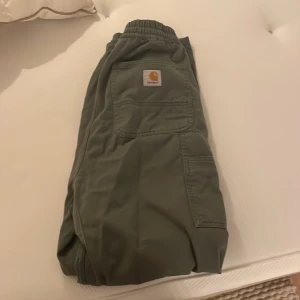 Carhartt byxor/cargopants - Mörkgröna i färgen. Storlek L men lite kortare i benen. För mig (185) passar dem pärfekt. Köpta för ca 2 månader sedan, tvättade 1 gång. Nypris 800kr.