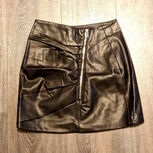 Svart kjol i fuskläder - Säljer nu min kjol från Bershka i helt fantastiskt skick. Inga anmärkningar. Storlek XS. Tillkommer fraktkostnad