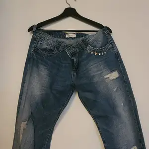 Jeans med nitar och slitna detaljer.