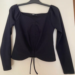 Långärmad offshoulder topp - Super snygg och skön långärmad tröja från Bikbok. Är i bra skick och kan justeras med de två banden så att den sitter precis som man vill ha den. Storlek L