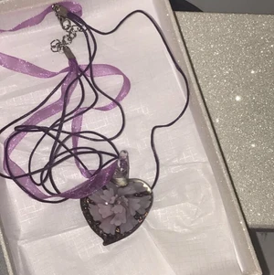 Halsband - Ett halsband med lila snören och ett fint hjärta med ett typ av mönster i!💜