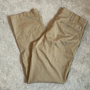 Carhartt Chinos 32x34 - Säljer mina carthartt chinos då jag inte använder dem längre. Chinosen har storleken 32x34. (87 cm i midjan & 81 cm i  inerbenslängd för referenser) Jag är 175cm lång, sitter perfekt i benen på mig. Skick-8/10💪🏻 skriv gärna till mig ang frågor/fler bilder