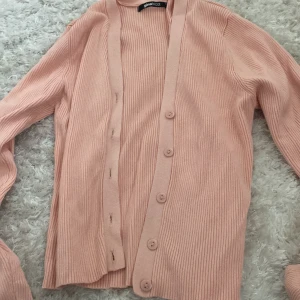 Rosa kofta - En kofta i jättefin rosa färg. (De 2 första bilderna är den riktiga färgen). Den är fin och passar till allt. Man kan ha den som topp eller kofta och ha något under. Den är lite croppad men inte så kort. Väldigt stretchig i matrialet. 