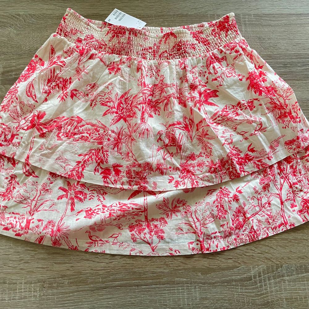 Helt ny kjol med lapp kvar Strl L från H&M  Naturvit botten med rött mönster Två volang lager Resår i midjan Nyskick då den är ny  Vikt 159 gram . Kjolar.