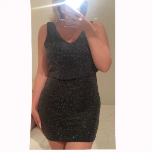 Svart ”glitter” klänning - Jätte fin svart ”glitter” klänning som är kryssad i ryggen den är kort 