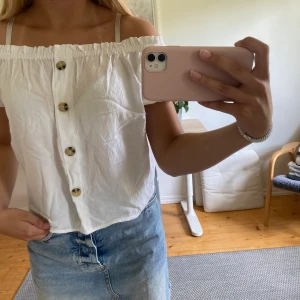 Vit ofshoulder T-shirt - Säljer en vit ofshoulder T-shirt med knappar från H&M🥰 återkommer med fraktkostnad vid intresse