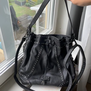 Väska - Svart/mörkgrå skinnväska med nitar. Finns både crossover och vanligt band💕