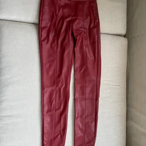 Röda skinnbrallor  - Röda snygga tighta skinnbyxor med dragkedja på vänster sida. Sitter som en smäck och är angelägna med en liten slits nertill. Använda ett par gånger men är i fint skick utan några synliga defekter.  Från Zara Trafaluc leggings collection