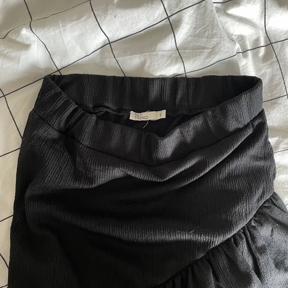supersöt & somrig svart kjol med volanger från Nelly i storlek S. sparsamt använd! är 164cm lång.. Kjolar.