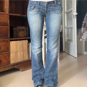 Lågmidjade jeans - Ett par superfina jeans med coola detaljer och knappstängning. Bilden är lånad och säljer pga dem tyvärr inte passade mig. Jeansen är även hyfsat långa!!! Midja: 80 cm || innerben:78 cm || ytterben: 98 cm
