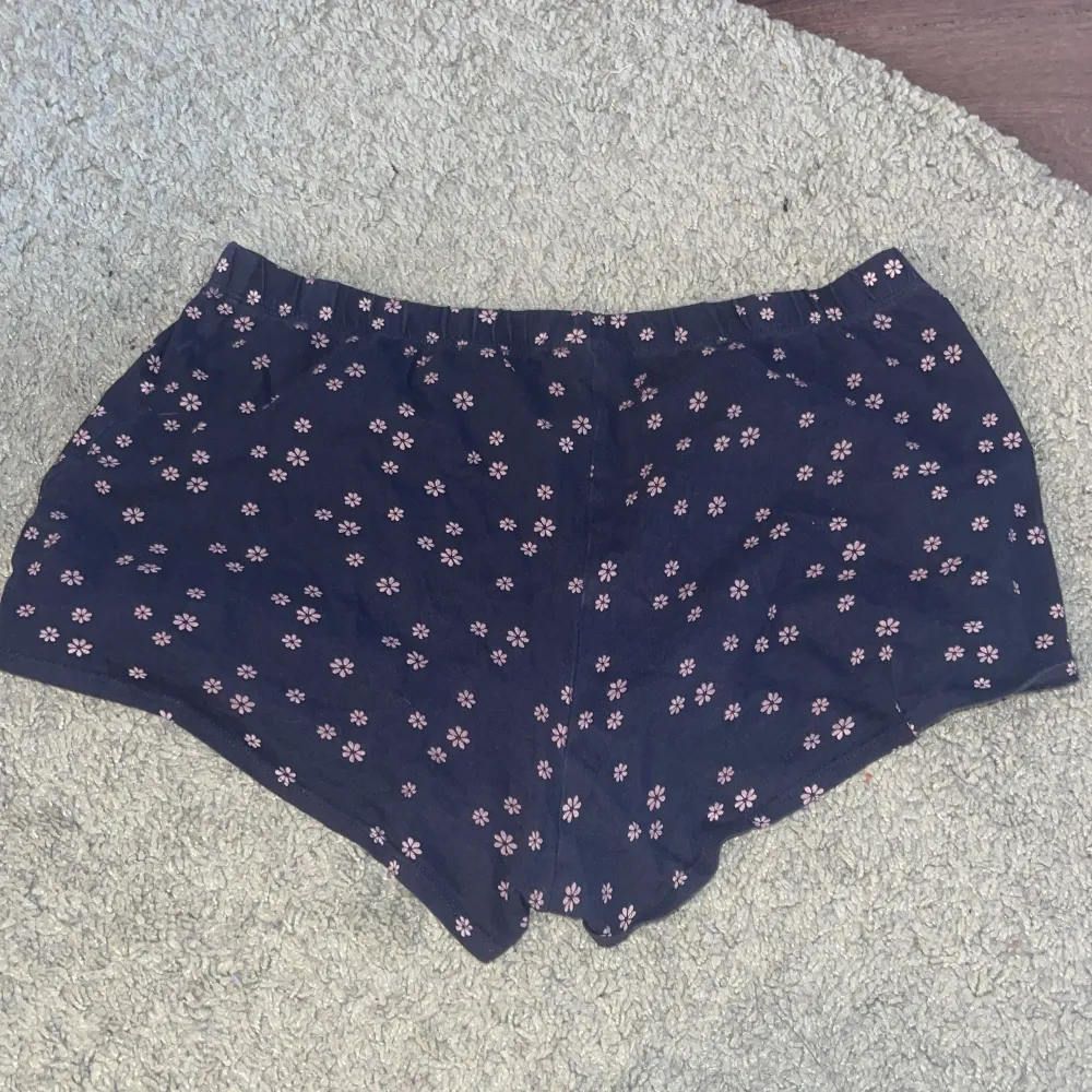 Mörkblå shorts med rosa blommor på från hm i strl 170. Shorts.