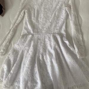 Långärmad vit klänning i spets. Använd fåtal gånger och är i fint skick. 200kr+frakt