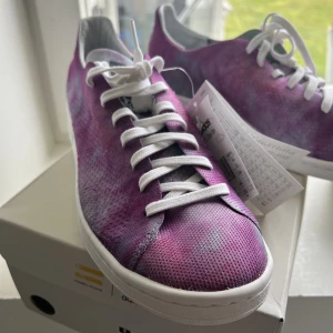 PW HU HOLI Stan Smith MC - Ett par helt nya skor med prislapp kvar. Köpt fel stolek, så enbart därför ja säljer dessa. Priset ja köpte dessa för är 1599 kr och säljer dom för 1 299.