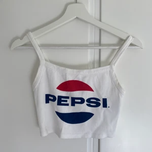 Croppat linne - Kort croppat linne med pepsitryck från Zara. I gott skick utöver de små blåa fläckarna bredvid i:et (se sista bilden), därav priset💛