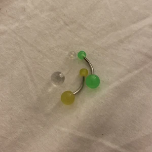 Navel percing  - En genomskinlig och gul och grön percing 