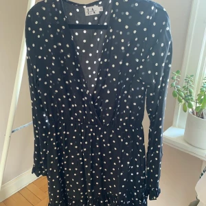 Prickig klänning från NAKD - Prickig klänning från NAKD med volang nedtill samt vid slutet av ärmen. Storlek 36. Utan anmärkningar. SKICKAS med postnords fraktpåse för 63kr, önskas spårbart tillkommer det.