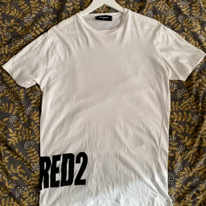 DSquared2 T-shirt  - Säljer en vit DSquared2 T-shirt med tryck bak och framtill. Mycket bra skick! Köpt under en resa till Kanada 2019.  - Storlek M 350 kr