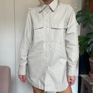 Oversized beige skjorta strl S - En oversized plastliknande skjorta (som jag använt som klänning med cykeltights) men kan såklart användas som jacka/skjorta till byxor. Från HM! Ser dyrare ut än vad den är vilket alltid är kul. Använd fåtal gånger 