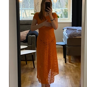 Spetsklänning  - Flower lace midi dress  Orange midiklänning i spets från & Other stories, storlek 36. Passar perfekt som strandklänning.