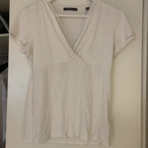 Vit t-shirt - Vit t-shirt med detalj vid bysten. V-ringad. Storlek M men passar även S. Från Esprit, sparsamt använd.