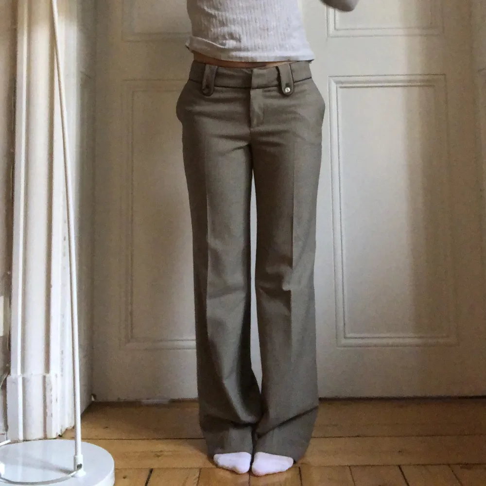 Brun grå kostymbyxor med låg midja och fina detaljer❣️ Midjemått: 73cm Innerbenslängd: 80cm (de är snyggt uppsydda och går att sprätta upp 6cm) Frakt 64kr. Jeans & Byxor.