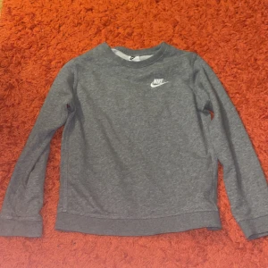 Grå Nike tröja för barn ( unisex ) - Jätte snygg grå Nike tröja som man kan ha med ett par jeans eller med mjukis. Säljer då den är för liten. Funkar både för flickor och pojkar.