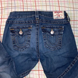 Lågmidjade true religion jeans y2k - Storleken är 27 och den är från true religion. Säljer för att den inte passsde mig tyvärr, kontakta mig gärna innan du köper