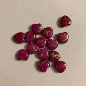Priset gäller alla pärlor. 14 stycken pärlor. De är rosa hjärtan med guld streck. Säljes billigt då jag vill bli av med de. Frakt tillkommer på 15kr! TRYCK INTE PÅ KÖP NU!
