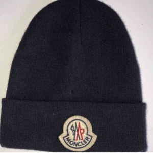 Moncler mössa - Mössa i mörk blå färg nästan svart. Hologram och QR kod finns i mössan.