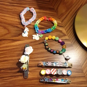 Hårspännen och armband - Armband med antingen pärlor eller loombands.  Hårspännen med pärlor, blommor eller knappar. Köparen betalar frakt på 29kr. Du kan också beställa smycken som du själv bestämmer hur de ska se ut. Vi har loombands o pärlor (stora o små), blommor o knappar.