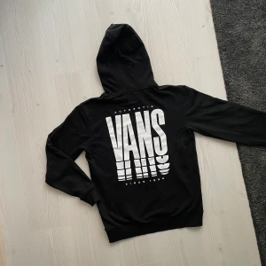 VANS - Svart hoodie - En supercool streetig hoodie från VANS i toppskick! Lite pösig i passformen och har coolt tryck på ryggen