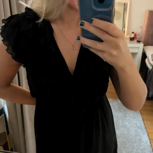 Super snygg oanvänd klänning - Svart oanvänd klänning från H&M med fina detaljer fram