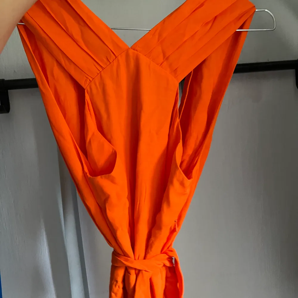 En helt ny orange klänning som passar olika stilar. Ettikett kvar. Klänningen har en öppen rygg och ett knytband runt midjan. Den är i storleken S/38🧡 Hör av dig ifall du är intresserad! 🧡. Klänningar.