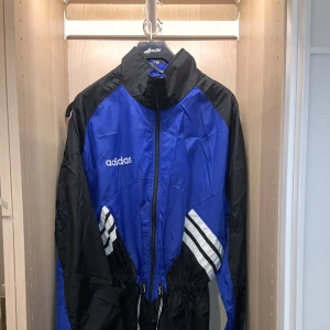 Adidas vintage jacka  - Lång vindjacka Adidas med justerbara band i höften. 